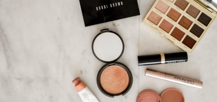 photo of assorted makeup products on gray surface